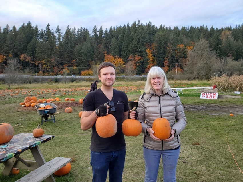 taking a picture with a huge pumpkins